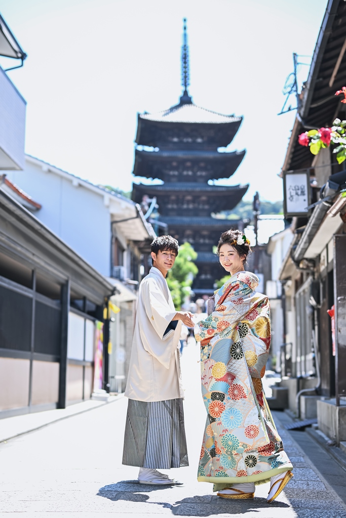 五重塔とカメラに向かって振り向く新郎新婦