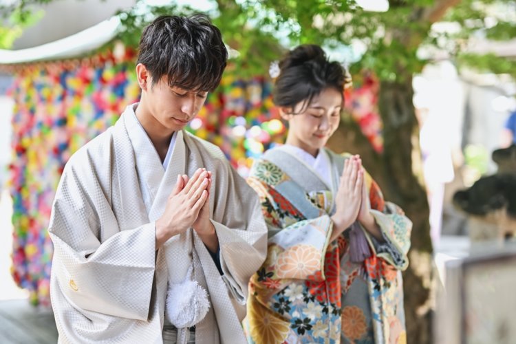 カラフルなお守りが可愛いお寺でお参りするお二人