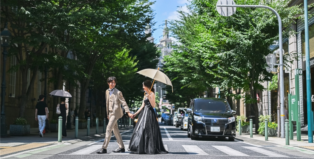 旧居留地で横断歩道を手をつないで歩く新郎新婦
