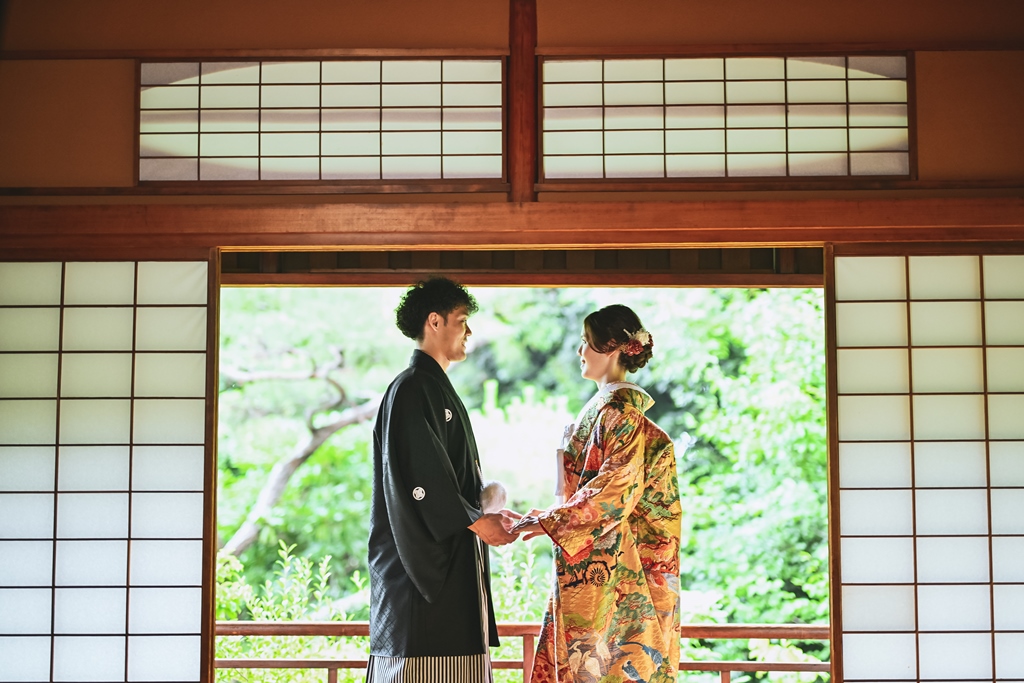 和室で手をつないでいる新郎新婦