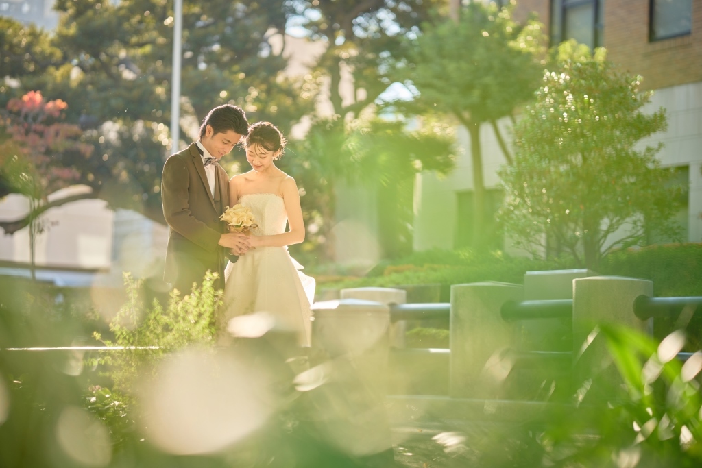 緑の奥でブーケを持つ二人