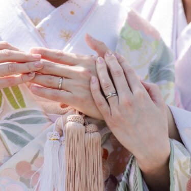 重ねた両手の指輪と、色打掛の刺繍や房飾りを写したクローズアップ。和装前撮りのディテールカット