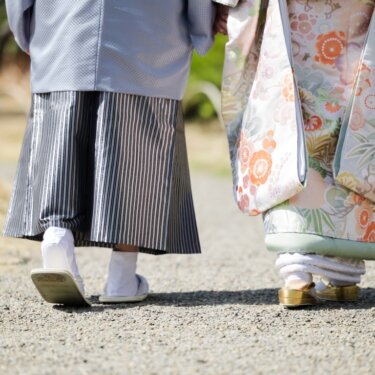 小道を歩く新郎新婦の足元のクローズアップ。袴と色打掛の裾、草履が写る和装前撮りの一枚