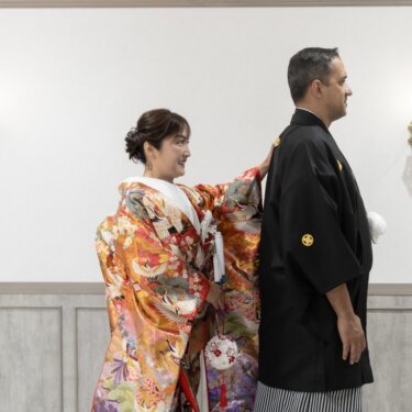 背を向けて待つ新郎の背中に手を添える色打掛の花嫁。ファーストミート直前の和装フォトウェディング