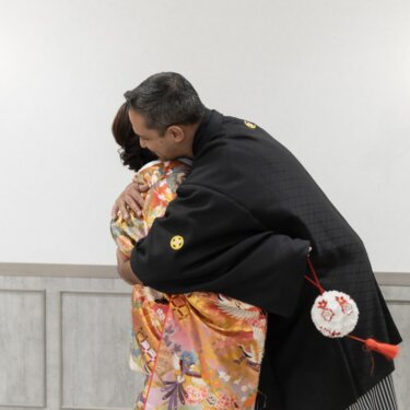 深く抱き合う紋付袴の新郎と色打掛の花嫁。ファーストミートの感動を写した和装の結婚写真