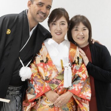 家族の女性と3人で並んで笑う、色打掛の花嫁と紋付袴の新郎。和装前撮りで残す家族写真