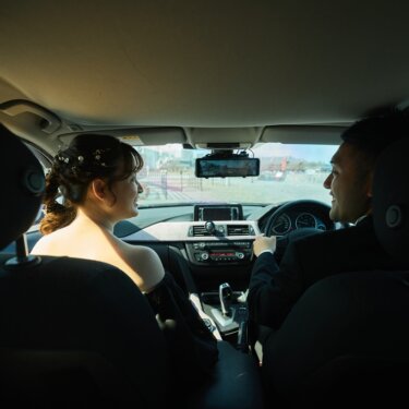 愛車の車内で見つめ合う、助手席の花嫁と運転席の新郎。二人の思い出の車で撮る結婚写真