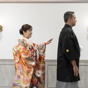 壁灯のある部屋で、背を向けた新郎に手を伸ばす色打掛の花嫁。ファーストミートの和装前撮り