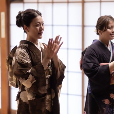 着物姿の家族の女性2人が拍手で祝福する笑顔のスナップ。家族と一緒のフォトウェディング