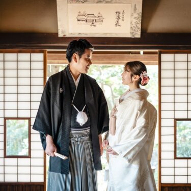 障子の座敷で見つめ合う黒紋付袴の新郎と白無垢の花嫁。昔ながらの日本家屋で撮る和装前撮り