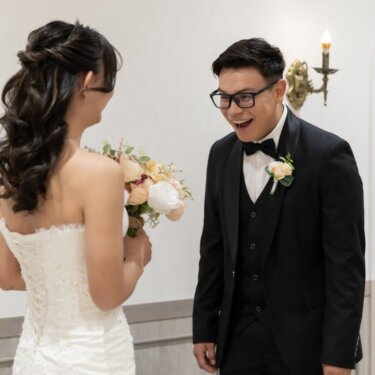 ドレス姿の花嫁と対面して大笑いする新郎。ファーストミートの続きを写したスタジオフォト