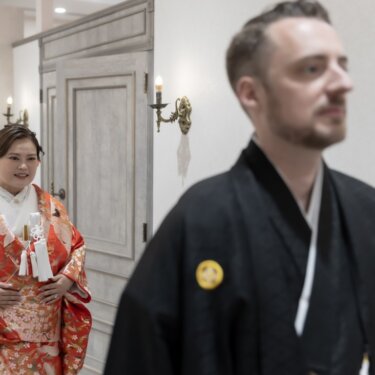 扉から現れた花嫁を新郎がぼかしの奥で振り返る、ファーストミートの瞬間を写した印象的な前撮り