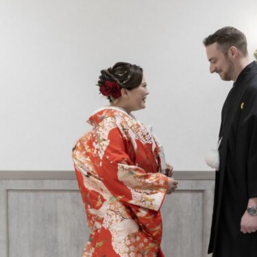 振り返った新郎と見つめ合い、大きく笑う鶴柄の色打掛の花嫁。ファーストミートの瞬間の結婚写真