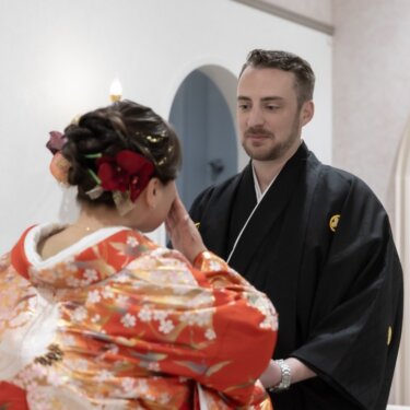 新郎が色打掛の花嫁の頬にやさしく手を添える、真剣な表情のファーストミートの和装フォトウェディング