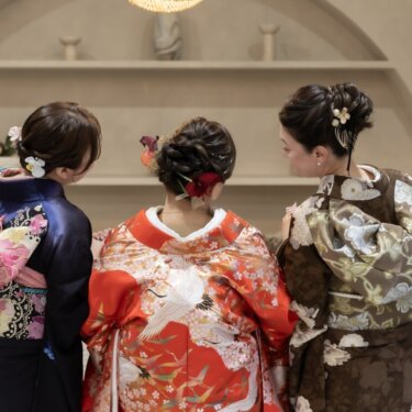 色打掛の花嫁と振袖・訪問着の家族の女性3人の後ろ姿。帯結びが美しい和装前撮りの家族写真