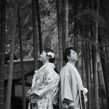 竹林を背に背中合わせで静かに佇む新郎新婦の横顔。モノクロで仕上げた和装フォトウェディング