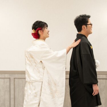 ろうそく型の壁灯の前で、花嫁が後ろから新郎の背中に手を添えるファーストミート。白無垢と紋付袴の和装前撮り