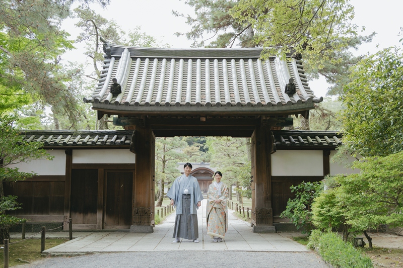 三溪園の門の前に並んで立つ和装の新郎新婦