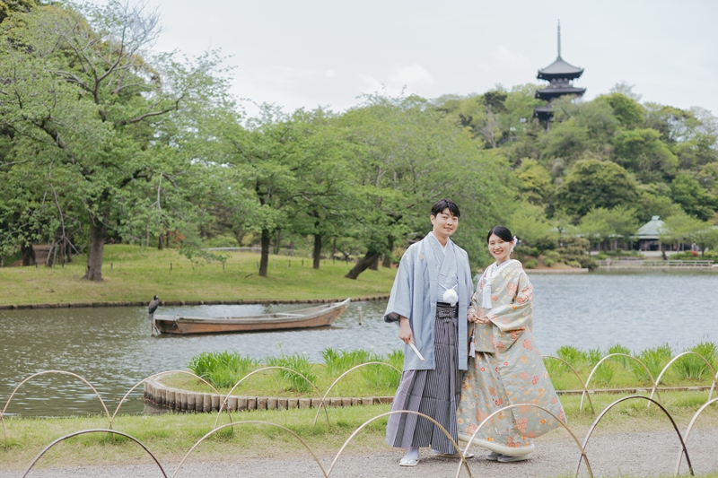 三溪園の池のほとりで塔を望む新郎新婦の後ろ姿