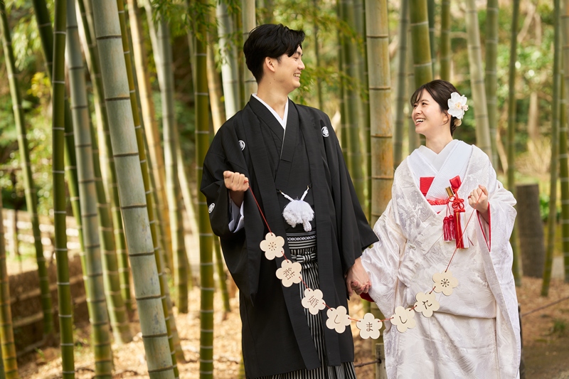 竹林で手をつなぎ微笑み合う和装の新郎新婦