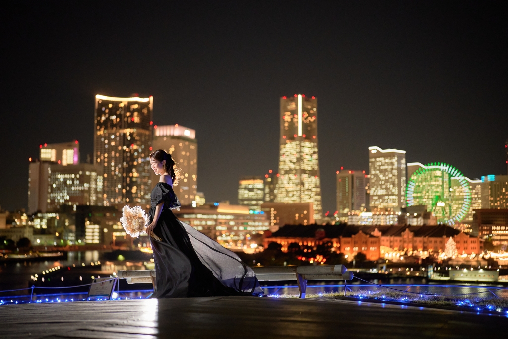 夜のみなとみらいの夜景を背景に黒いドレスを翻す新婦