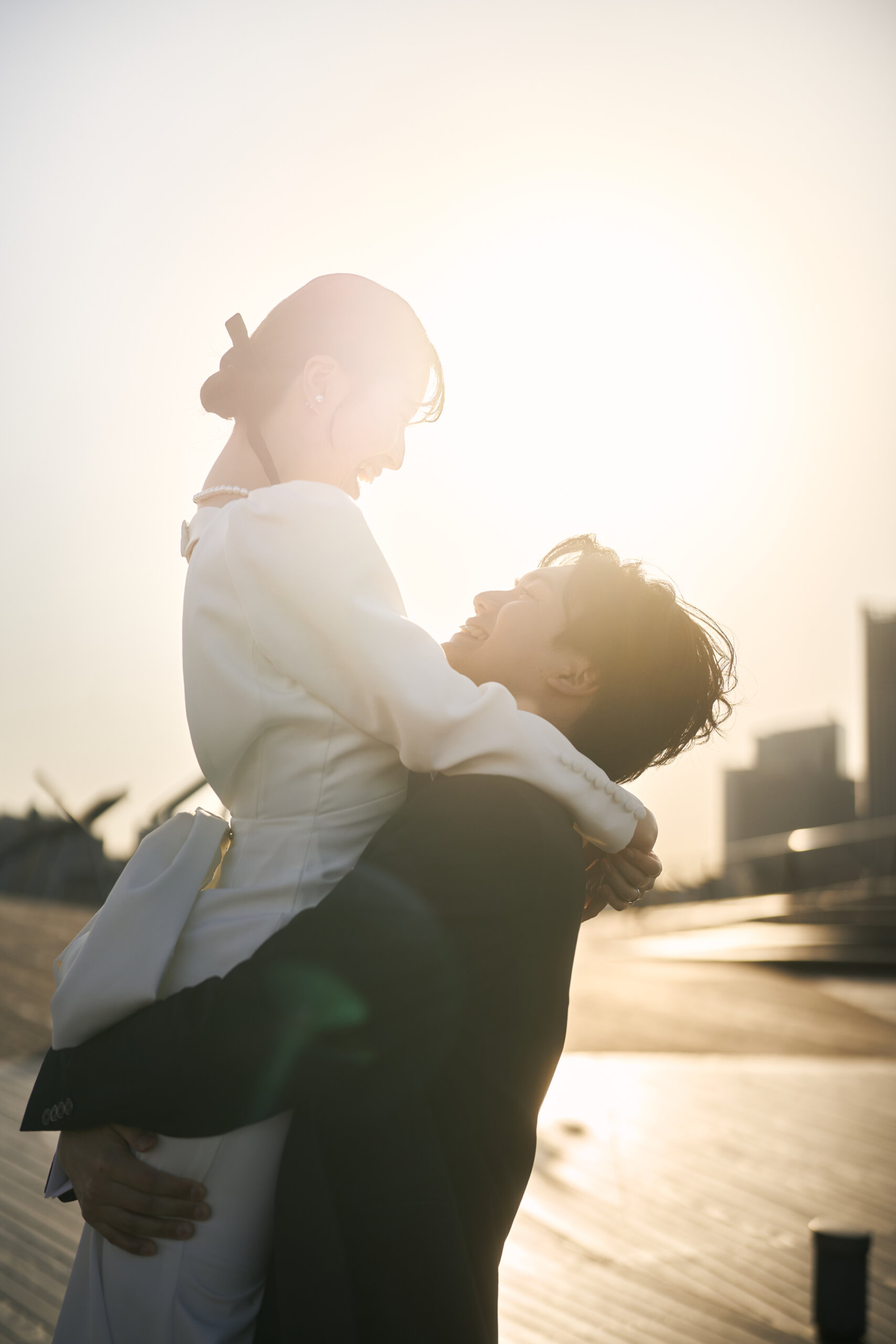 日中のみなとみらいを背景にブーケを持ち寄り添って歩く新郎新婦