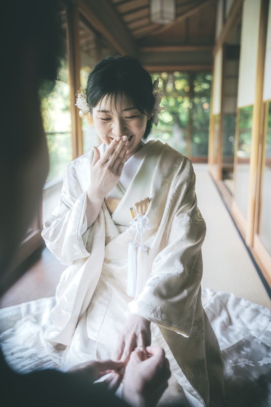 庭園を眺めながら手を添え合う新郎新婦