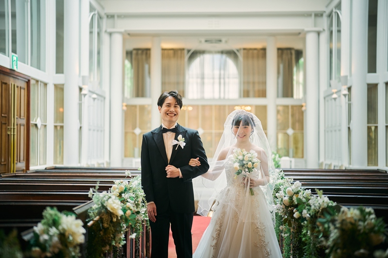 キャンドルの灯る階段の上で手を取り合う新郎新婦の後ろ姿