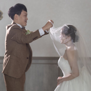 ベールを持ち上げる新郎と、ベールの中で照れ笑いする花嫁。横浜のスタジオで撮るベールアップの前撮り
