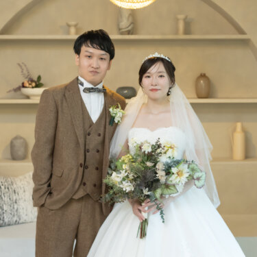 アーチの棚とペンダントライトのあるスタジオで並んで立つ新郎新婦。グリーンのブーケとティアラが映える横浜のフォトウェディング