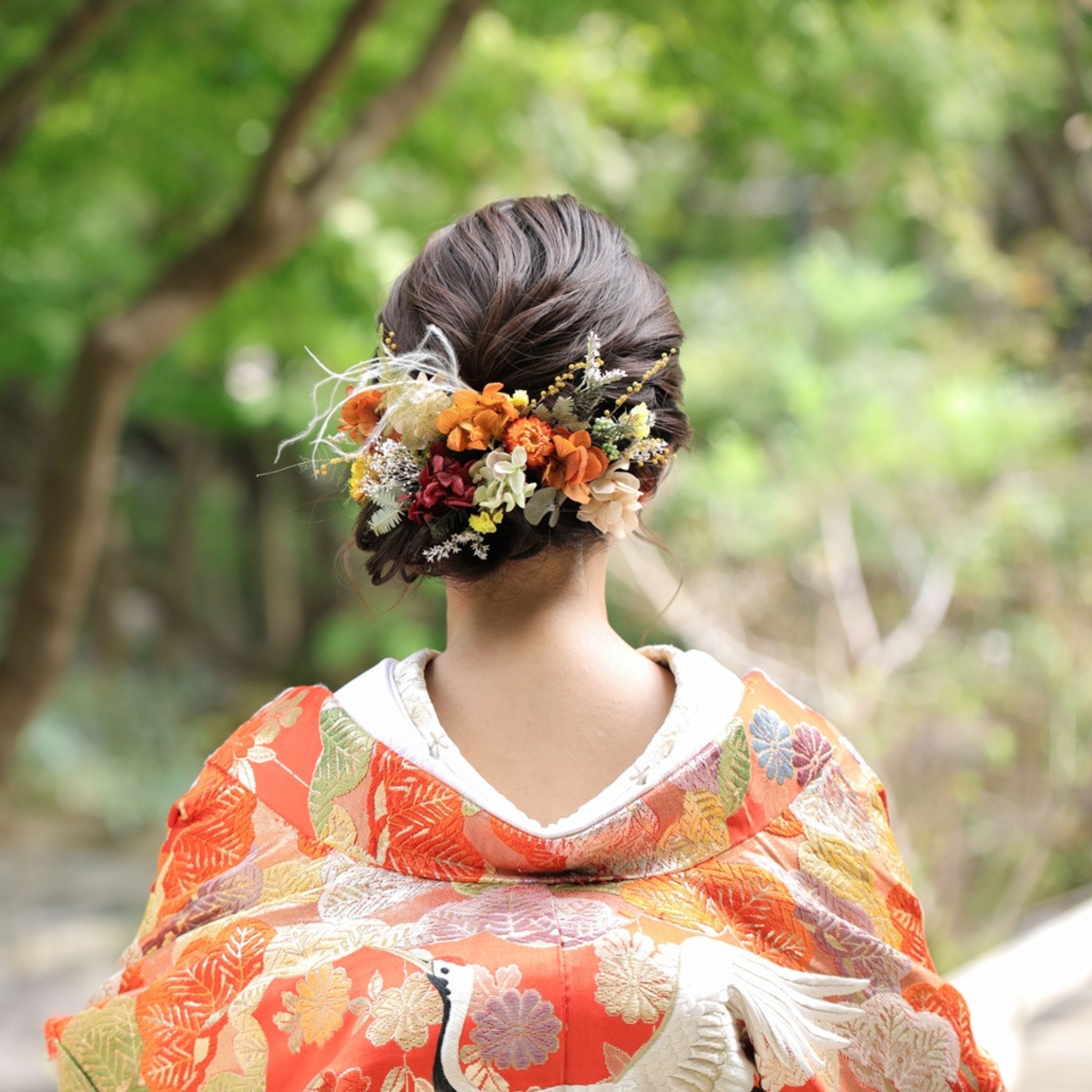鮮やかなオレンジと白の生花を飾った、色打掛に合う和装ヘアメイク