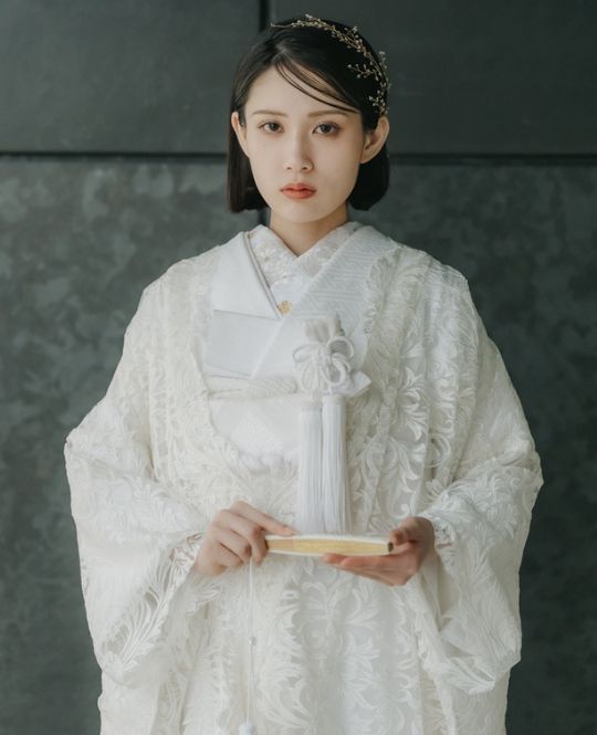 繊細なレースを贅沢に施した、他にはない上品な佇まいの総レースの白無垢。純白の中に柔らかな陰影が生まれ、清らかさの中に優雅な気配が漂う一着です。伝統美を大切にしながらも、レースならではの軽やかさと華やぎが花嫁を包み込み、歩くたびに繊細な表情が浮かぶ、特別感あふれる白無垢です。（衣装番号白無垢　DE101）